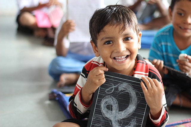 A boy smiles through his first day at school. (Image courtesy: Akshaypatra)